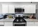 Modern kitchen features stainless steel appliances and white cabinets at 11945 Lovejoy Crossing Way, Hampton, GA 30228