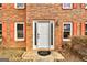 White front door with brick facade and orange shutters at 6191 Valley Green Rd, Lithonia, GA 30058