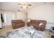 Living room features two brown sofas, a ceiling fan, and a fireplace at 74 Canterbury Dr, Grantville, GA 30220