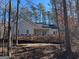 Newly constructed home with gray siding, a two-car garage, and a partially wooded lot at 5525 Belle Meade Dr, Villa Rica, GA 30180