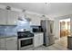 Modern kitchen features stainless steel appliances and blue tile backsplash at 123 Courtneys Ln, Fayetteville, GA 30215