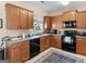 Kitchen with wood cabinets, black appliances and gray countertops at 1598 Thornwick Trce, Stockbridge, GA 30281