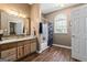 Well-lit bathroom with a wooden vanity, granite countertop, and tiled floors at 3806 Bill Gardner Pkwy, Locust Grove, GA 30248