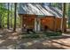 Quaint cabin nestled in the woods, featuring a charming porch with vintage signage and rustic details at 3806 Bill Gardner Pkwy, Locust Grove, GA 30248