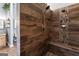 Custom shower with stone and wooden tile and a built-in seat at 3806 Bill Gardner Pkwy, Locust Grove, GA 30248