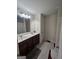 Double vanity bathroom with dark brown cabinets and tiled floors at 7019 Blue Sky Dr, Locust Grove, GA 30248