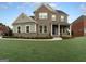 Two-story brick home with gray siding and landscaped lawn at 7019 Blue Sky Dr, Locust Grove, GA 30248