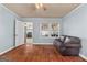 Bedroom with hardwood floors, light blue walls, and access to kitchen at 60 N East Main St, Hampton, GA 30228