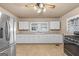 Kitchen with white cabinets, stainless steel appliances, and tile floors at 60 N East Main St, Hampton, GA 30228