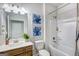 Bright bathroom with tub shower, single vanity, white toilet and blue flower art at 1467 Trellis Court (Lot 5), Hampton, GA 30228