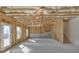 Unfinished basement with concrete floors, exposed wood framing, a door, and a window offering natural light at 5626 Wyncreek Sw Cir, South Fulton, GA 30331