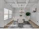 Virtually staged dining room, table set for six, with coffered ceiling and chandelier at 5626 Wyncreek Sw Cir, South Fulton, GA 30331