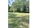 Large grassy backyard with a treeline and a wooden fence at 470 Harris Rockmore Loop, Covington, GA 30014