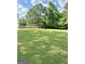 Large grassy backyard with trees and a wooden fence at 470 Harris Rockmore Loop, Covington, GA 30014