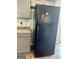 Black refrigerator in kitchen with gray cabinets and white backsplash at 470 Harris Rockmore Loop, Covington, GA 30014