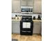 Kitchen with gray cabinets, black appliances, and white backsplash at 470 Harris Rockmore Loop, Covington, GA 30014