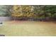 A view of a grassy backyard featuring a wooden fence and mature trees at 5738 Antelope Trl, Atlanta, GA 30349