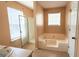 A bathroom featuring a window, shower, and a large bathtub at 5738 Antelope Trl, Atlanta, GA 30349