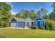 Exterior view of charming blue home featuring a well manicured front yard and two-car garage at 2037 Emily Dr, Social Circle, GA 30025