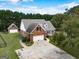 Aerial view of brick home with detached garage and beautiful front porch at 557 Arrowhead Cir, Rutledge, GA 30663