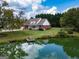 Secluded brick home with white trim, large yard, and serene pond featuring a floating dock to enjoy the water view at 557 Arrowhead Cir, Rutledge, GA 30663