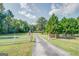 Home down long drive with fenced yard, trees and large, grassy area. American flags displayed at 677 Gum Creek Rd, Oxford, GA 30054