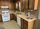 Galley kitchen with wood cabinets and white appliances at 5303 Kemper Pl, Stone Mountain, GA 30088