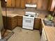 Galley kitchen with wood cabinets and white appliances at 5303 Kemper Pl, Stone Mountain, GA 30088