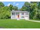 Gray house with red door, white porch, and green lawn at 3786 Glen Mora Dr, Decatur, GA 30032