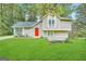 Two-story house with red door, light beige siding, and green lawn at 3951 Wabash Ln, Ellenwood, GA 30294