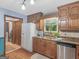 Bright kitchen featuring wood cabinets, granite counters, and a view into laundry area at 930 Singley Dr, Locust Grove, GA 30248