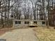 Tan mobile home with wooden deck, situated on a wooded lot at 58 Pinewood Dr, Carrollton, GA 30116