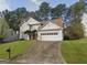 Two-story house with tan exterior, white garage door, and landscaping at 635 Watson Bay, Stone Mountain, GA 30087