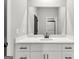 Modern bathroom with a white vanity, marble countertop, and large mirror at 8950 Callaway Drive, Winston, GA 30187