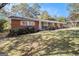 Newly renovated ranch home with brick and gray siding, showcasing a landscaped lawn at 1091 Pine St, Conyers, GA 30012