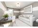 A cozy, neutral living room with a comfortable couch and a desk area, illuminated by a modern light fixture at 740 Ocmulgee Crossing, Locust Grove, GA 30248