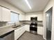 Modern kitchen with white cabinets, granite countertops, and stainless steel appliances at 2959 Fairburn Rd, Atlanta, GA 30331