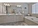 Bathroom with double vanity, soaking tub, and a large mirror at 32 American Walk, Peachtree City, GA 30269