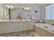 Bathroom with double vanity, soaking tub, and a large mirror at 32 American Walk, Peachtree City, GA 30269