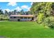 Brick ranch house with a large green lawn and mature trees at 3138 Beechwood Dr, Lithia Springs, GA 30122