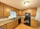 Kitchen with wood cabinets, granite countertops, and black appliances at 3138 Beechwood Dr, Lithia Springs, GA 30122