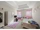 Bright bedroom featuring a plush rug, built-in dresser, and a cozy bed with pink accents at 319 Allegrini Dr, Atlanta, GA 30349