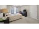 Well-lit bedroom features a tray ceiling, plush carpet, and large window and a dark wood dresser at 319 Allegrini Dr, Atlanta, GA 30349