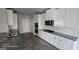 Modern kitchen featuring white cabinets, stainless steel appliances, and herringbone backsplash at 352 Traditions Ln, Hampton, GA 30228