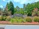 Landscaped entrance to The Landings community featuring a stone sign and lush greenery at 100 Aspen Way, Fayetteville, GA 30214