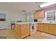 Kitchen with island, oak cabinets, white appliances, and access to backyard at 100 Aspen Way, Fayetteville, GA 30214