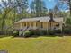 Home exterior with a covered porch and lush green lawn at 7377 Asbury Dr, Lithonia, GA 30058