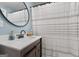 Simple bathroom with wood vanity, round mirror and striped shower curtain at 405 Miller Rd, Covington, GA 30014