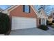 Two-car garage with white doors and a concrete driveway at 2673 Northforke Ct, Tucker, GA 30084