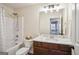 Well-lit bathroom features modern vanity with marble countertop, classic dark wood cabinet and shower-tub combo at 429 Burgundy Se Ter, Atlanta, GA 30354